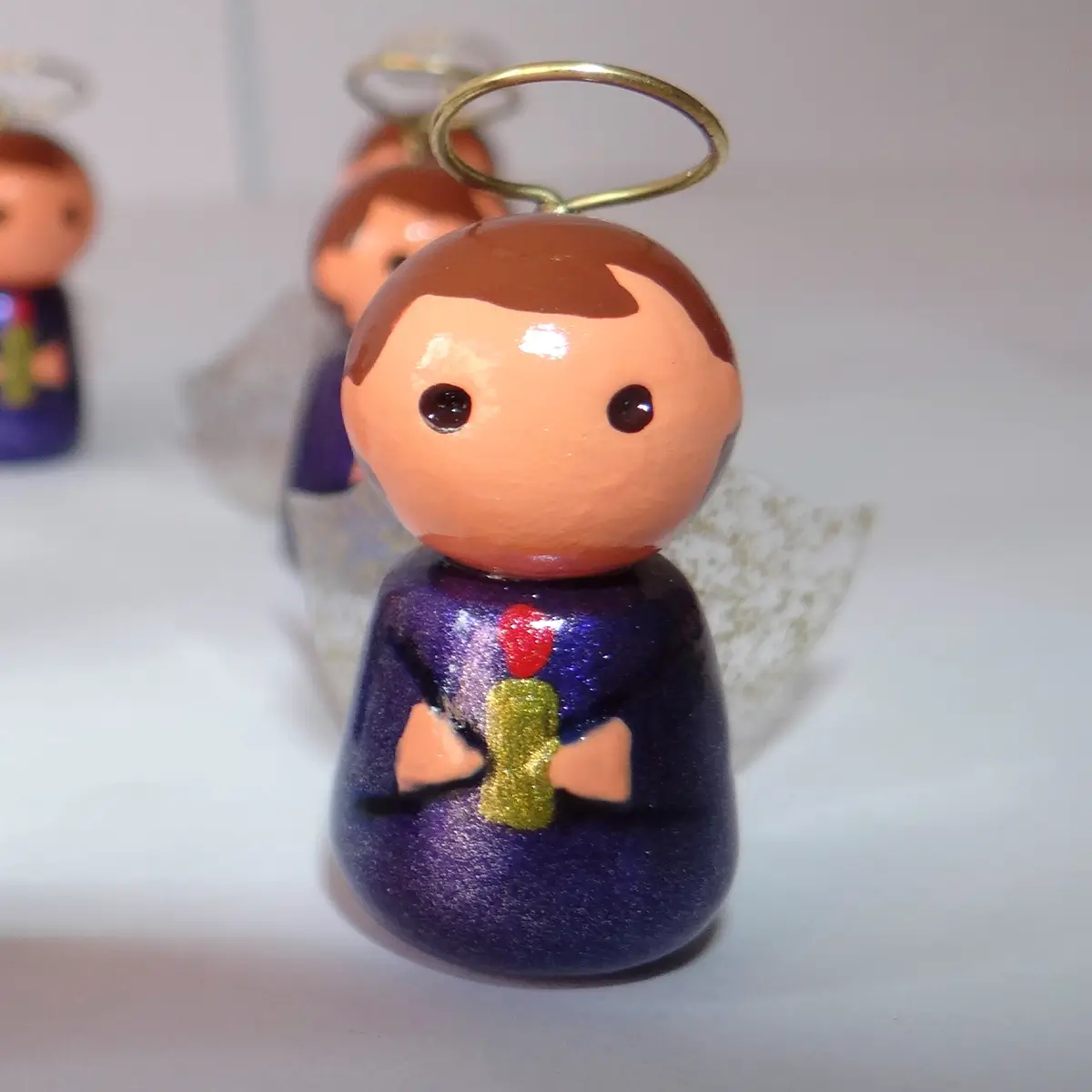 Detalle de ángel de luz morado con modelado a mano y aureola en alambre.