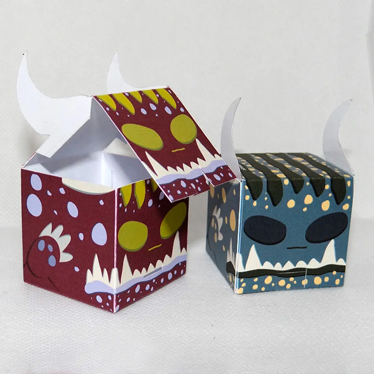 cajas de halloween tipo monstruo en colores vino y gris con cuernos