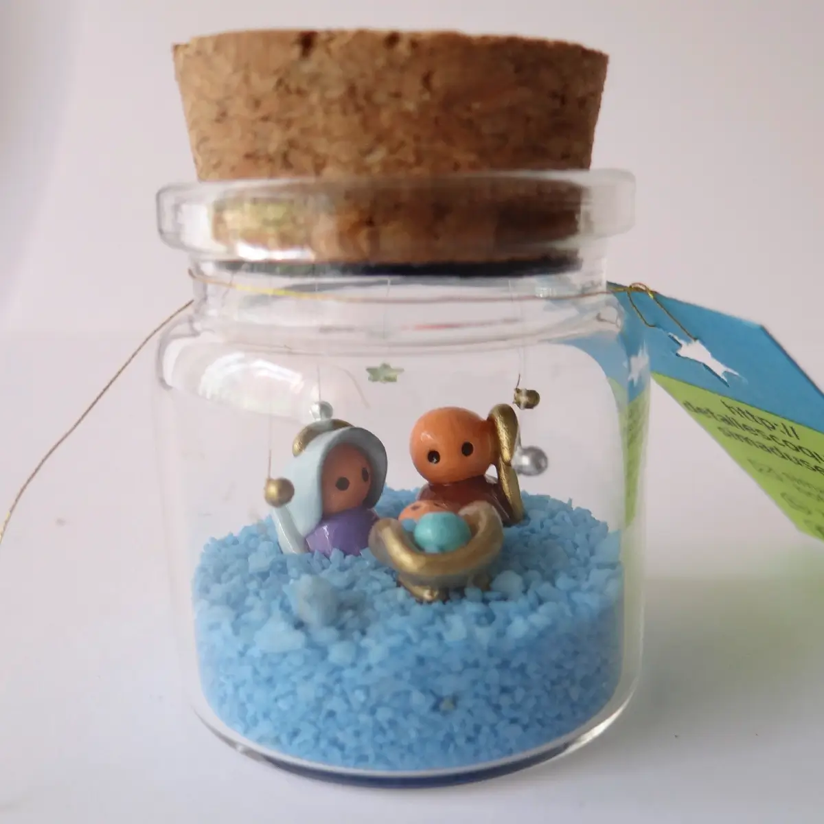 Nacimiento en botella de vidrio con piedras decorativas azules