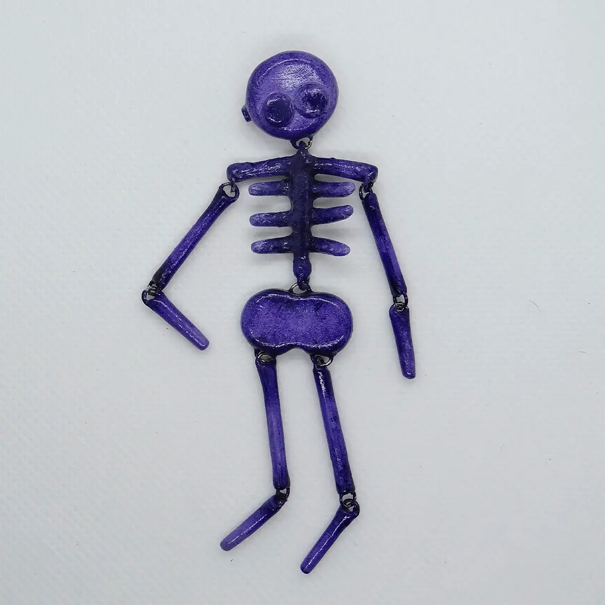 Prendedor de esqueleto morado en porcelanicrón